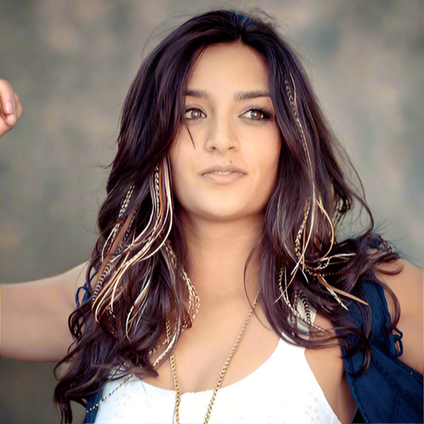 Woman with long, wavy hair and a neutral expression against a blurred background
