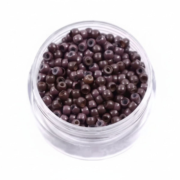 Clear container filled with small brown  hair beads on a white background