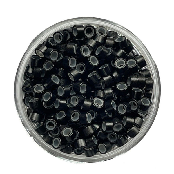 Clear container filled with black hair tie ends on a white background
