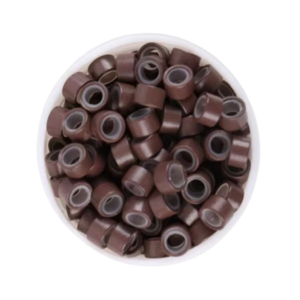 Brown 5mm size hair beads in a white bowl on a white background