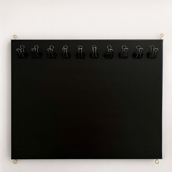 Black board with metal clips on a white background