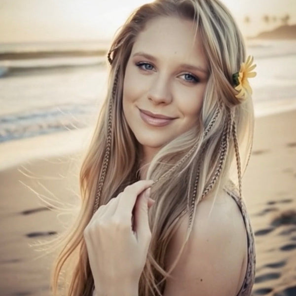 Woman with long blonde hair and a flower in her hair, at the beach