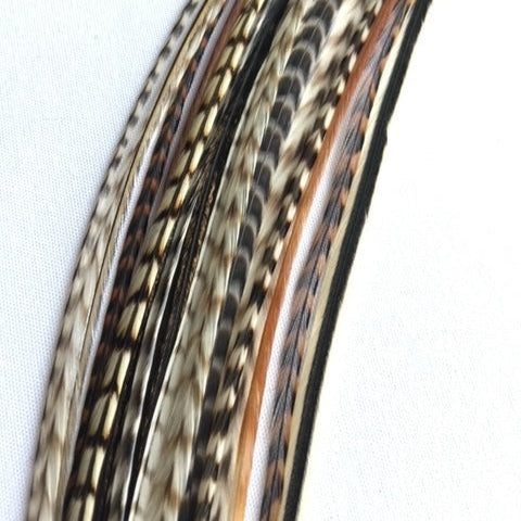 Close-up of bunch of natural hair feathers with grizzly pattern on a white background