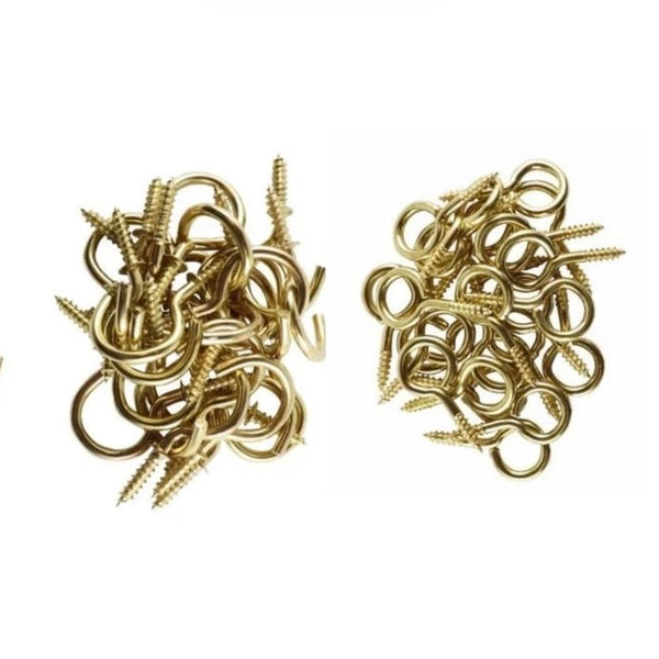 Two piles of gold eye hooks on a white background