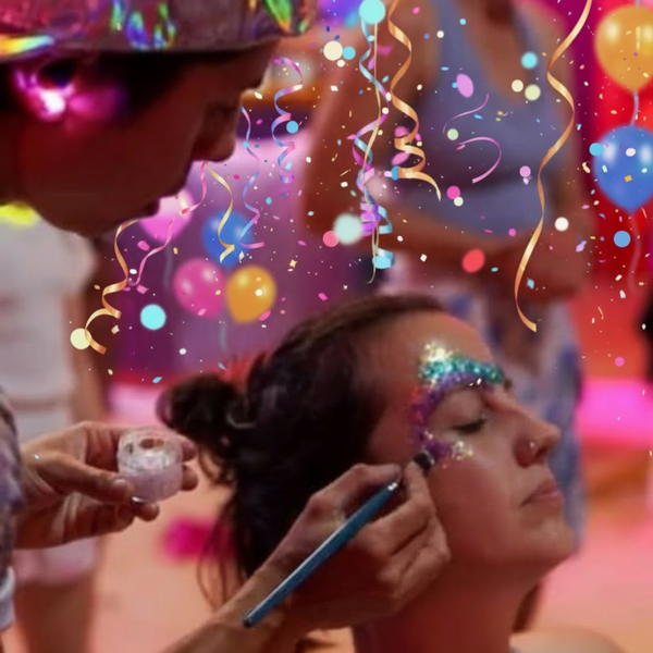 Person applying glitter makeup to another person at a party with colourful lighting