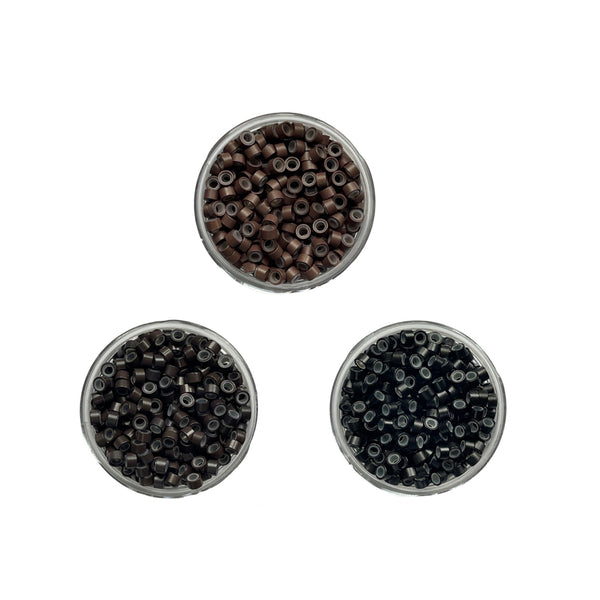Three round containers of black and brown hair beads on a white background