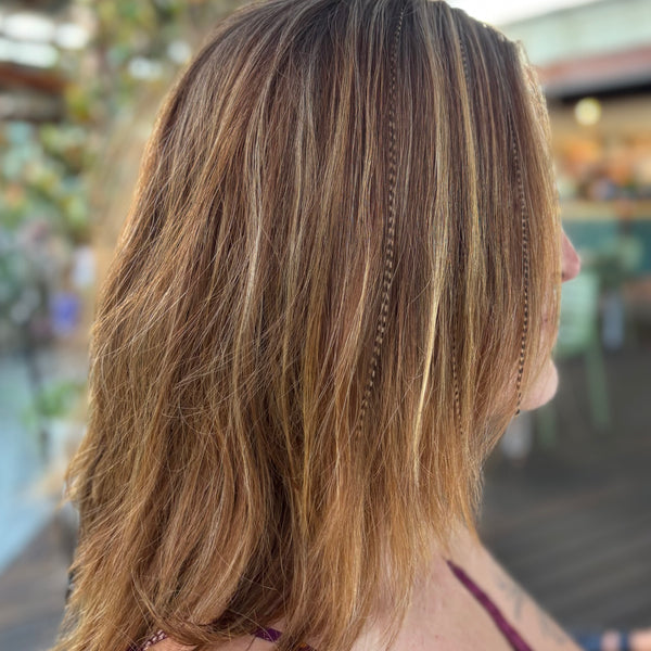 Close-up of a person with long, wavy hair in an outdoor setting
