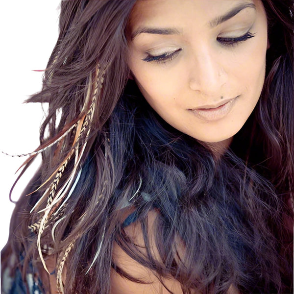 Close-up of a person with long, wavy hair , natural feather extensions and a subtle smile.