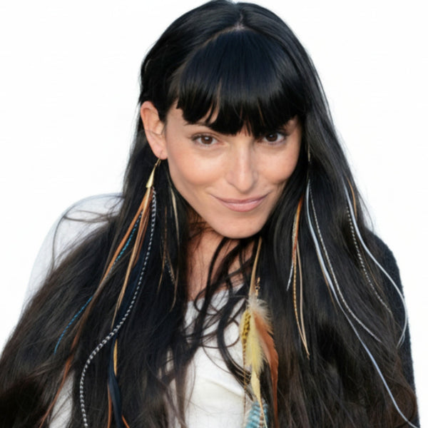 Woman with long dark hair and feathered hair extensions on a white background