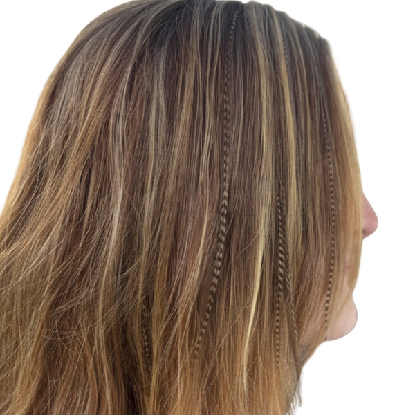 Close-up of a person with fawn grizzly feather extensions in hair on a white background