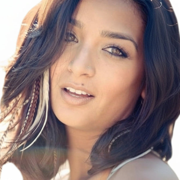 Close-up of a woman with feathered hair against a blurred background