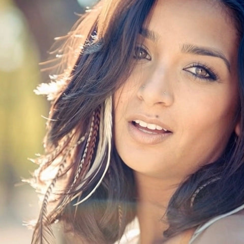 Close-up of a woman with feathered hair against a blurred background