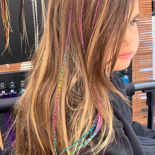 Person with colorful hair extensions in a salon setting