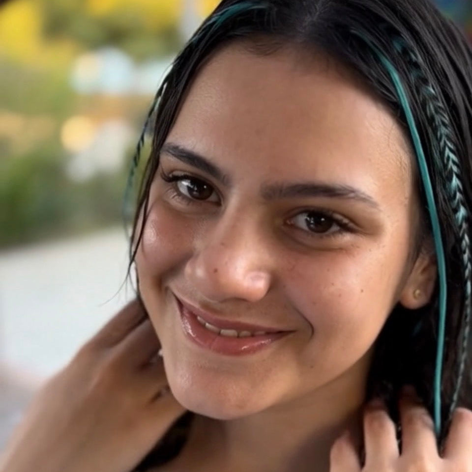 Woman with blue hair feathers smiling outdoors