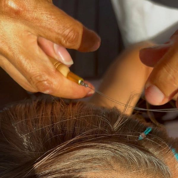 Close-up of hair extensions being worked on with tools