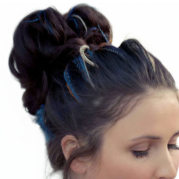 Close-up of a woman's hair styled in an updo with blue hair feathers on a white background