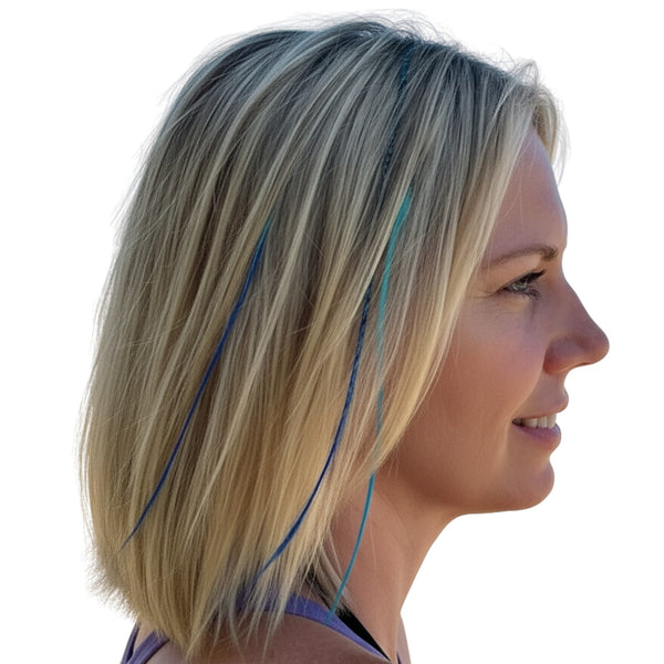 Side profile of a woman with blonde hair  and blue ombre feather extensions on a white background