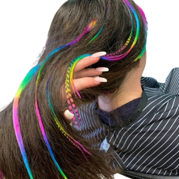 Person with real rainbow feather hair extensions styled in long brunette hair