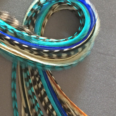 A bundle of wide and skinny feathers in turquoise, blue, and natural colors, with various patterns and colors mixed in.
